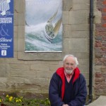 John outside the Eyemouth Tourist Information Centre, showing his painting of the Eyemouth disaster, 14 October 1881
